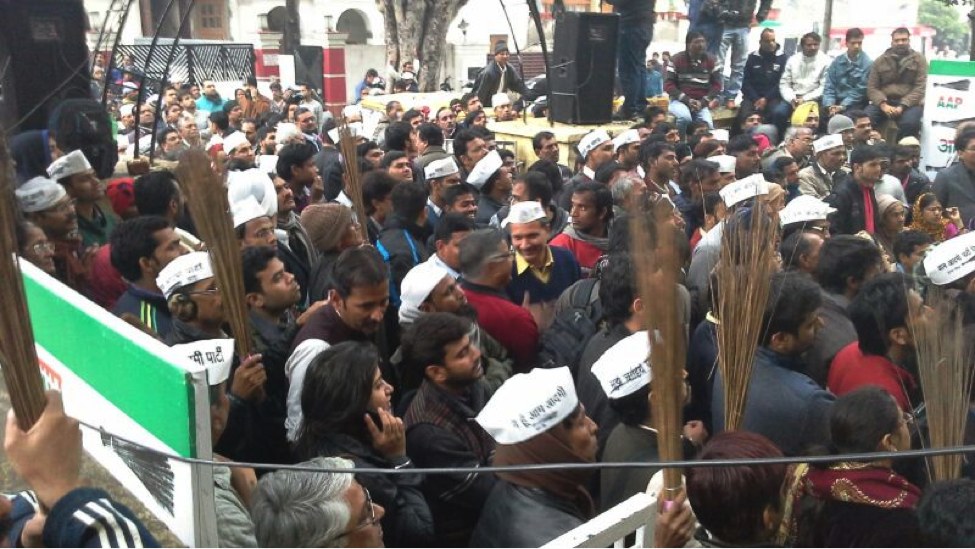 AAP supporters wearing the party cap and holding up brooms, their election symbol. Photo: Yotsana Tripathi